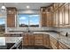 Charming kitchen featuring granite countertops, stylish cabinets, and a view of the landscape through a large window at 2590 Luke St, Pahrump, NV 89060
