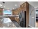 Modern kitchen design featuring stainless steel refrigerator, granite countertops, custom cabinets and view of the exterior at 2590 Luke St, Pahrump, NV 89060