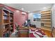 Inviting home office with large desk, custom bookcase, decorative red walls and view of the landscape at 2590 Luke St, Pahrump, NV 89060