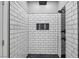 Contemporary shower features white subway tile, black trim, and a modern shower head with mosaic-tiled flooring at 2590 Luke St, Pahrump, NV 89060