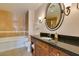 Bright bathroom features a tiled shower-over-tub, vanity with storage, and ornate mirror at 30 Strada Di Villaggio # 521, Henderson, NV 89011