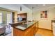 Bright kitchen features a tile breakfast bar, stainless steel appliances, and wood cabinets at 30 Strada Di Villaggio # 521, Henderson, NV 89011