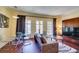 Comfortable living area with stylish seating, glass table and media center, bathed in natural light from large windows at 30 Strada Di Villaggio # 521, Henderson, NV 89011