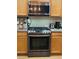 Close up shot of gas range and microwave in Kitchen with laminate flooring and wooden cabinets at 3160 Del Dotto Walk, Henderson, NV 89044