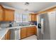 The kitchen features a stainless steel refrigerator, dishwasher and a double sink beneath a window at 320 Cimmarron Pl, Pahrump, NV 89048