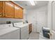 A practical laundry room with oak cabinets, washer, dryer and tile flooring at 320 Cimmarron Pl, Pahrump, NV 89048