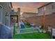 Inviting backyard featuring a cozy seating area with green artificial grass and string lights at 340 Largo Vista Ct, North Las Vegas, NV 89084