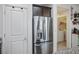 Stainless steel refrigerator alongside a door and access to laundry room at 340 Largo Vista Ct, North Las Vegas, NV 89084