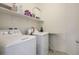 Bright laundry room featuring modern washer and dryer units, storage shelves, and ample space at 340 Largo Vista Ct, North Las Vegas, NV 89084