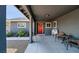 Inviting covered front porch with sitting area, white trim windows, and a red front door at 3675 W Maule Ave, Las Vegas, NV 89118