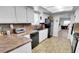 Functional kitchen featuring wood floors, stainless steel sink, and black appliances at 3675 W Maule Ave, Las Vegas, NV 89118