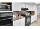 Well-equipped kitchen featuring modern black appliances, white cabinetry, and durable countertops at 3675 W Maule Ave, Las Vegas, NV 89118