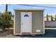 The exterior of a practical storage shed with a charming arched door and neutral color at 3675 W Maule Ave, Las Vegas, NV 89118