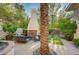 Outdoor patio area with a fireplace, landscaped greenery, seating, and hardscape at 3863 Glasgow Green Dr, Las Vegas, NV 89141