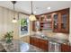 Stylish bar area with granite counters, glass cabinets and view of the pool at 3863 Glasgow Green Dr, Las Vegas, NV 89141