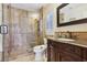 Bathroom with stylish vanity, stone shower, and travertine tile, creating a relaxing and functional space at 3863 Glasgow Green Dr, Las Vegas, NV 89141