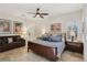 Cozy bedroom features a sitting area, ceiling fan, neutral walls, and a comfortable bed at 3863 Glasgow Green Dr, Las Vegas, NV 89141