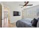 Comfortable bedroom with a ceiling fan, TV, neutral walls, and bright windows with shutter coverings at 3863 Glasgow Green Dr, Las Vegas, NV 89141