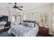 Bright bedroom with a ceiling fan, a comfortable bed, shuttered windows, and a seating area at 3863 Glasgow Green Dr, Las Vegas, NV 89141