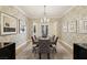 Formal dining room with crystal chandelier, decorative wallpaper and seating for six at 3863 Glasgow Green Dr, Las Vegas, NV 89141