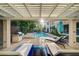 Outdoor kitchen with a grill, lounge chairs, and a view of the sparkling pool at 3863 Glasgow Green Dr, Las Vegas, NV 89141