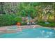 Refreshing pool and spa with chairs for lounging surrounded by mature trees and lush landscaping at 3863 Glasgow Green Dr, Las Vegas, NV 89141