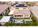 Aerial view showcases home with solar panels, outdoor kitchen, dining area, putting green, and landscaping at 3929 Reyes Ave, Las Vegas, NV 89141