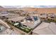 Wide aerial view highlighting houses in a neighborhood equipped with solar panels, set against desert hills at 3929 Reyes Ave, Las Vegas, NV 89141