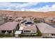 High-definition aerial view showing solar panels on a home with a backyard patio and a neighborhood close to desert hills at 3929 Reyes Ave, Las Vegas, NV 89141