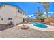 Backyard view of in-ground pool, covered patio, rock landscaping, and block wall for privacy at 3963 Redwood St, Las Vegas, NV 89103