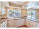 Well-lit kitchen with white cabinets, stone countertops, and backyard pool views at 3963 Redwood St, Las Vegas, NV 89103