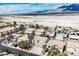 Wide aerial view showing a neighborhood near mountains and desert with solar panels on the roofs at 4208 Lower Saxon Ave, North Las Vegas, NV 89085