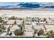 Stunning aerial view of a neighborhood with solar panels, desert landscape and mountain views at 4208 Lower Saxon Ave, North Las Vegas, NV 89085