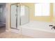 Bathroom showcasing a glass shower and tiled tub in a bright, sunny space at 4208 Lower Saxon Ave, North Las Vegas, NV 89085