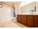 Bright bathroom features double sink vanity with wood cabinets and a shower over tub at 4208 Lower Saxon Ave, North Las Vegas, NV 89085