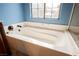 Bathroom with a soaking tub featuring tile surround and natural light at 4208 Lower Saxon Ave, North Las Vegas, NV 89085