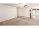 Open living area with neutral carpet, ceiling fan, and access to the backyard at 4360 Wendy Ln, Las Vegas, NV 89115