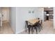 Dining area featuring a wooden table and black chairs with tiled flooring leading to the kitchen at 5166 Silverheart Ave, Las Vegas, NV 89142