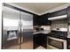 Kitchen features stainless steel fridge, granite counters, and dark cabinets with tile backsplash at 5166 Silverheart Ave, Las Vegas, NV 89142