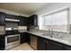 Well-lit kitchen featuring stainless steel appliances, granite countertops, and dark cabinetry at 5166 Silverheart Ave, Las Vegas, NV 89142