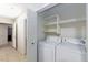Convenient laundry room showcasing a modern washer and dryer, complete with ample shelving space at 5166 Silverheart Ave, Las Vegas, NV 89142