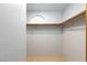Bright walk-in closet featuring a high shelf with a clothing rod and a decorative window at 5166 Silverheart Ave, Las Vegas, NV 89142