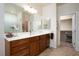 Bright bathroom features a double sink vanity with wood cabinets, tiled floors, and a walk-in closet at 609 Viale Machiavelli Ln, Henderson, NV 89011
