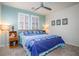Comfortable bedroom with a queen-size bed, ceiling fan, blue accent wall, and bright natural light at 609 Viale Machiavelli Ln, Henderson, NV 89011