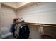 Walk-in closet with wood shelving and hanging rods, providing ample storage space for clothing and accessories at 609 Viale Machiavelli Ln, Henderson, NV 89011