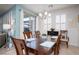 Bright dining room with a wooden table set for six, complemented by stylish window shutters and modern lighting at 609 Viale Machiavelli Ln, Henderson, NV 89011