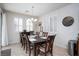 Elegant dining area featuring a spacious table and chairs, complete with modern light fixture and window coverings at 609 Viale Machiavelli Ln, Henderson, NV 89011