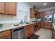 Kitchen featuring stainless steel dishwasher, granite countertops, window, and wood cabinets at 609 Viale Machiavelli Ln, Henderson, NV 89011