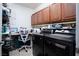 Laundry room with dark cabinets, front loading washer, and dryer at 609 Viale Machiavelli Ln, Henderson, NV 89011