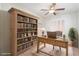 Bright office with large bookshelf, desk, ceiling fan, and natural light at 609 Viale Machiavelli Ln, Henderson, NV 89011